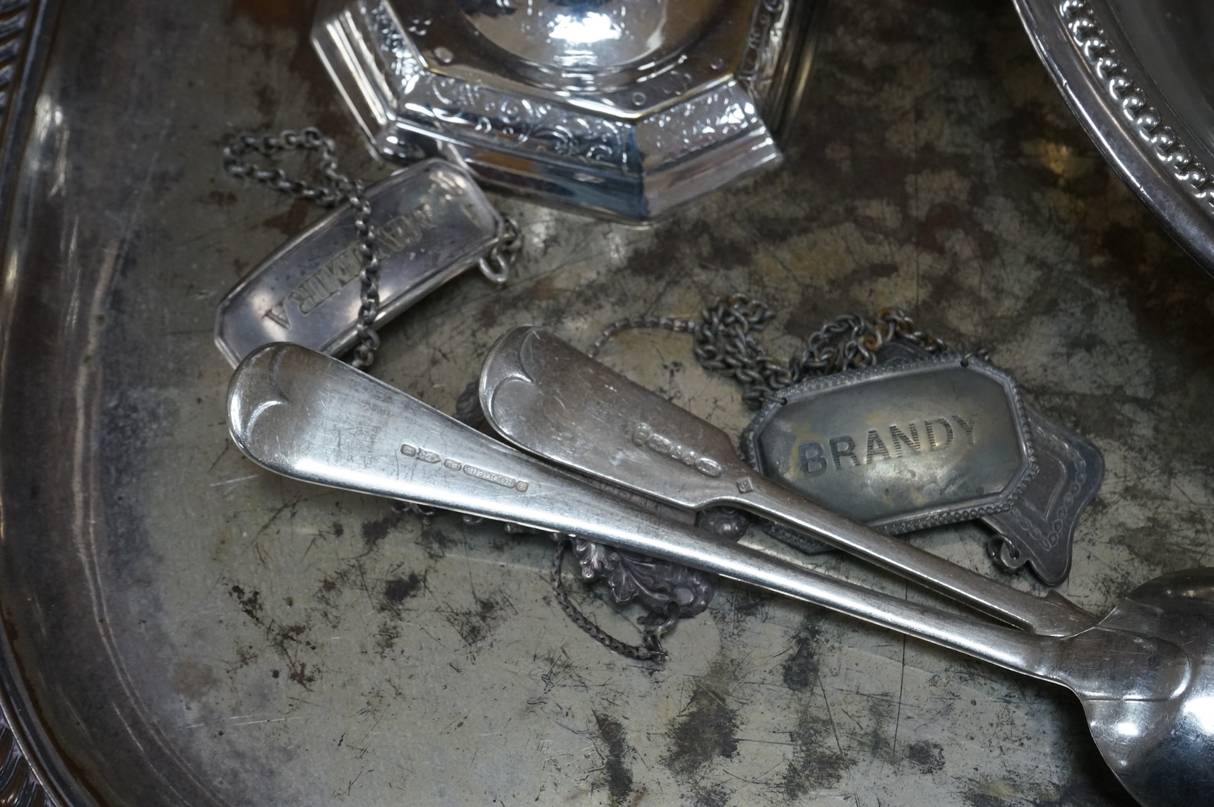 A pair of white metal candlesticks, a silver plated teapot circular tureen and cover spoons and forks and four spirit labels and large tray. Tray 73cm wide